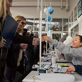 image of student welcoming visitors during Open House